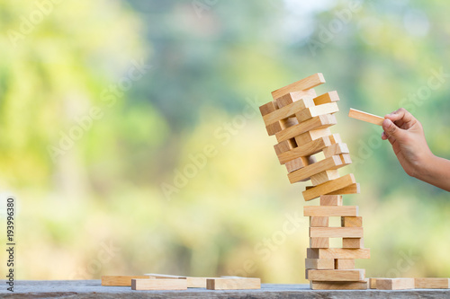The jenga game ,tower stack from wooden blocks toy and  hand take on block