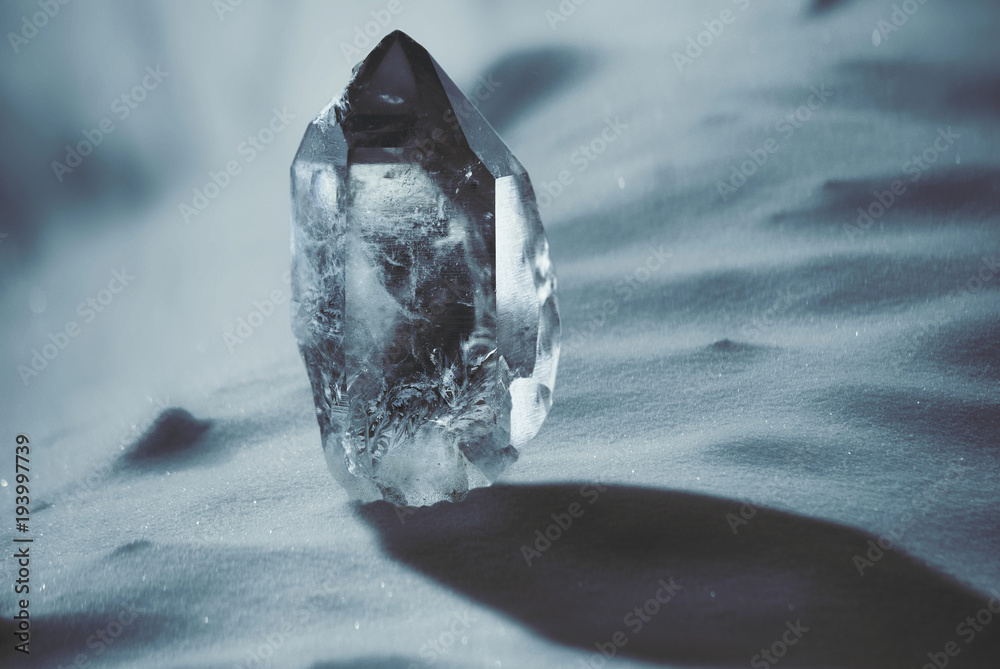 Large quartz crystal on a snowy background close-up - obrazy, fototapety, plakaty 