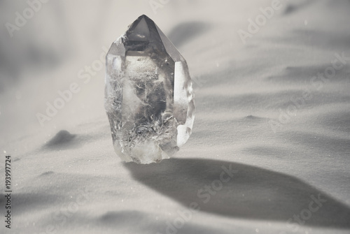 Large quartz crystal on a snowy background close-up