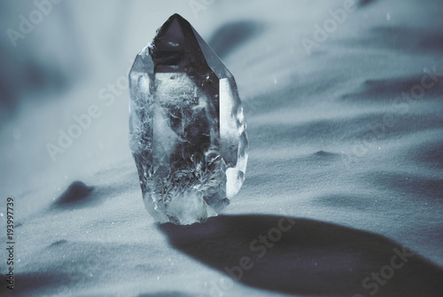 Large quartz crystal on a snowy background close-up