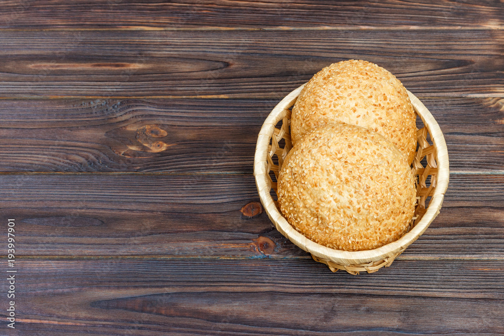 Tasty bun with basket bread on wooden background Tasty bun with basket bread on wooden background