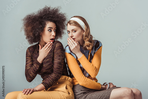 multicultural retro styled girls gossiping isolated on grey