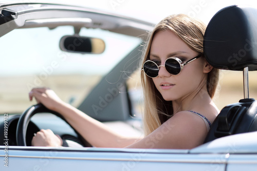 Girl driving a convertible car in a summer poppy field © spaskov