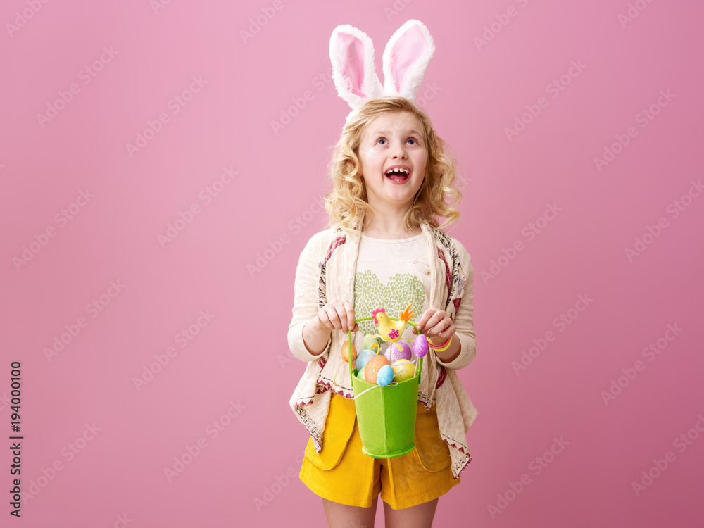 child with festive Easter eggs basket looking at copy space