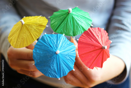 close-up of multi colored paper parasols  held by a girl