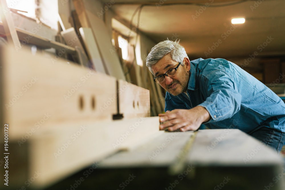 middle aged carpenter working in his workshop middle aged carpenter working in his workshop