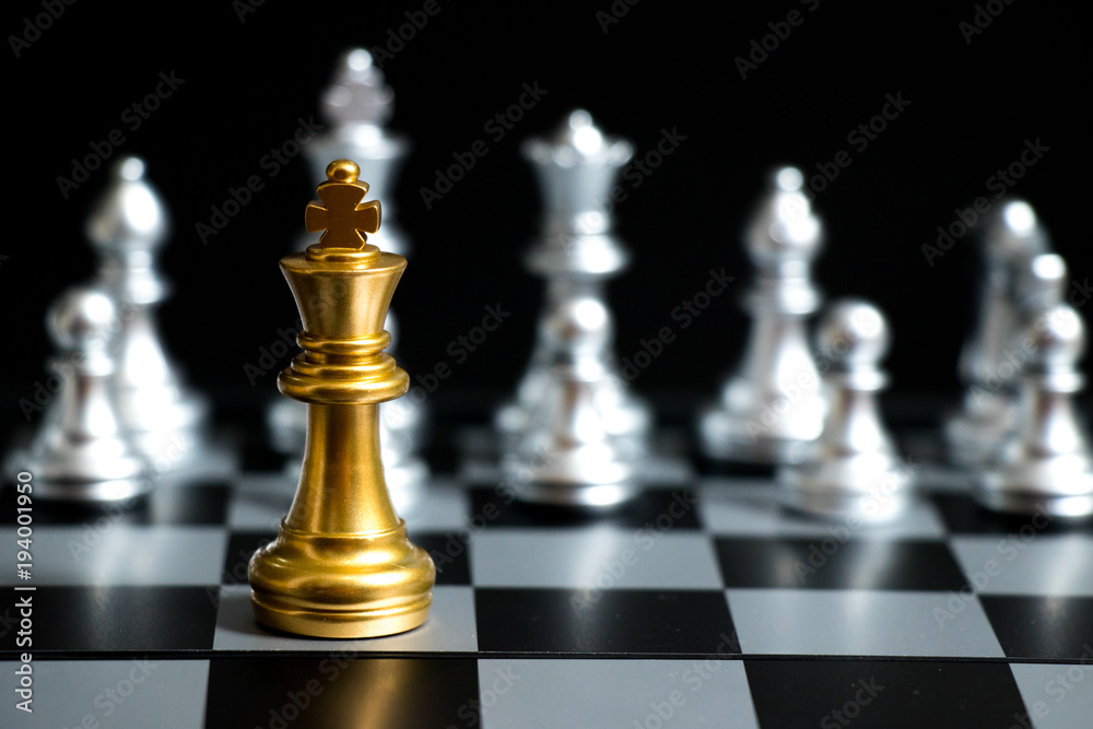 Gold King in chess game face with the another silver team on black background (Concept for company strategy, business victory or decision) Gold King in chess game face with the another silver team on black background (Concept for company strategy, business victory or decision)