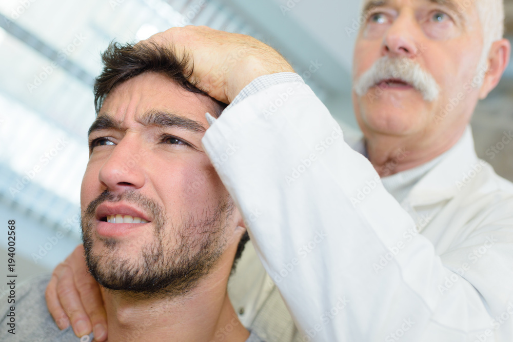 Obraz premium physiotherapist massaging patient with neck pain