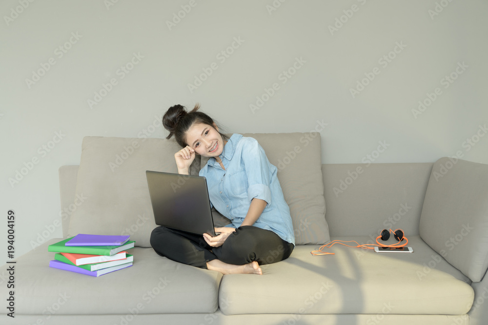 Business woman using laptop sitting on sofa. Young girl shopping online use notebook surfing internet. happy mood on cozy couch. Business and working concept. Business woman using laptop sitting on sofa. Young girl shopping online use notebook surfing internet. happy mood on cozy couch. Business and working concept.