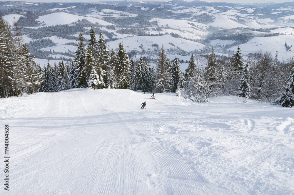 Skiers on the ski slope in the snowy Carpathian mountains Skiers on the ski slope in the snowy Carpathian mountains