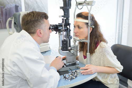 male optician giving female patient an eye test