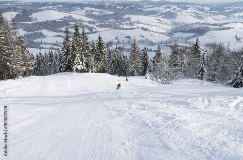 Skiers on the ski slope in the snowy Carpathian mountains