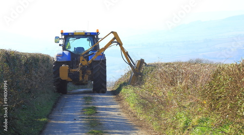 Tractor mounted hedge cutter on a country road in East Devon