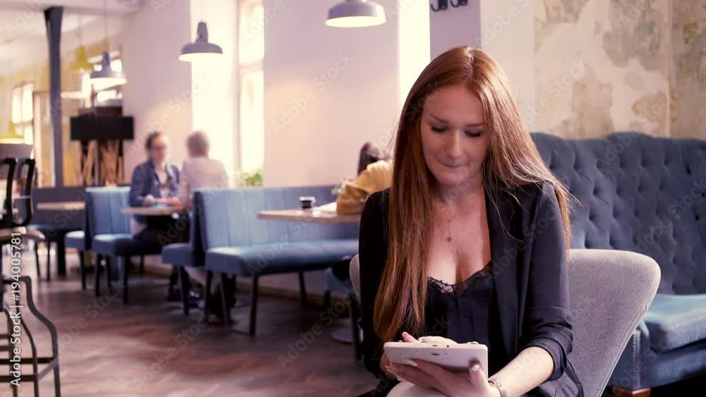 Young beautiful businesswoman sitting withn tablet in cafe
Young beautiful businesswoman sitting withn tablet in cafe