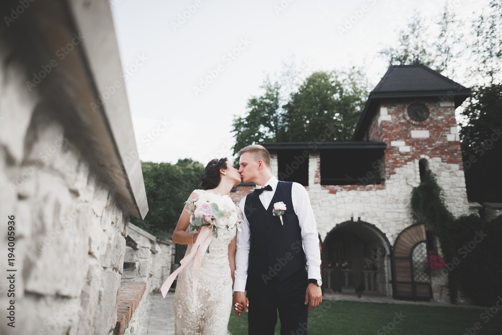 Fototapeta premium Happy wedding couple walking in a botanical park