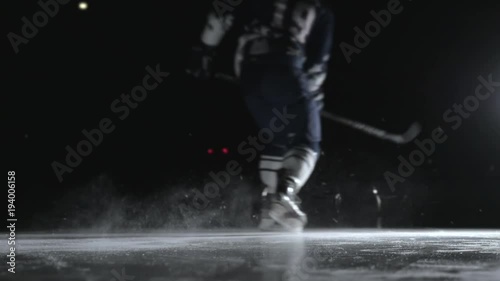 Ice Hockey player performing slap shot isolated on black background close up photo