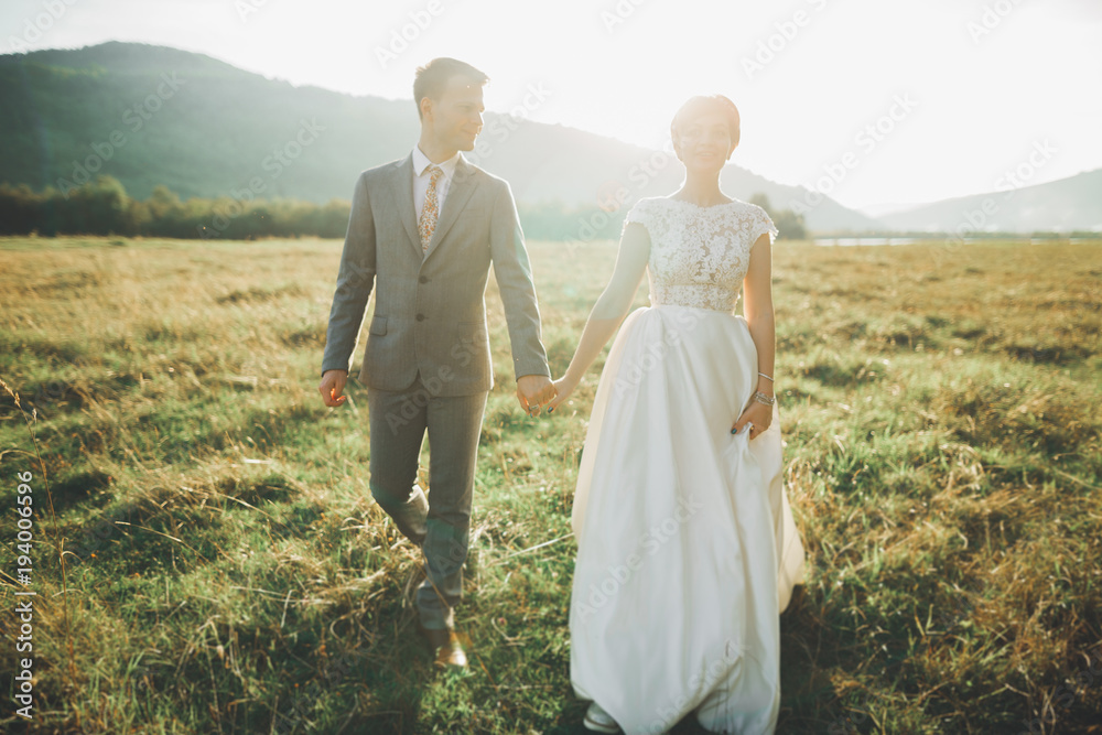Beautiful wedding couple, love on the sunset. Fielf with view on mountains Beautiful wedding couple, love on the sunset. Fielf with view on mountains