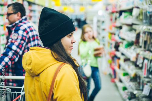 woman walk by mall. seeking goods on shelf of store