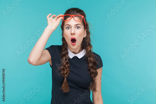 Surprised woman in red glasses amazement looking at camera