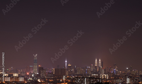 Night view of Kuala Lumpur city skyline with dusty and thick fog.