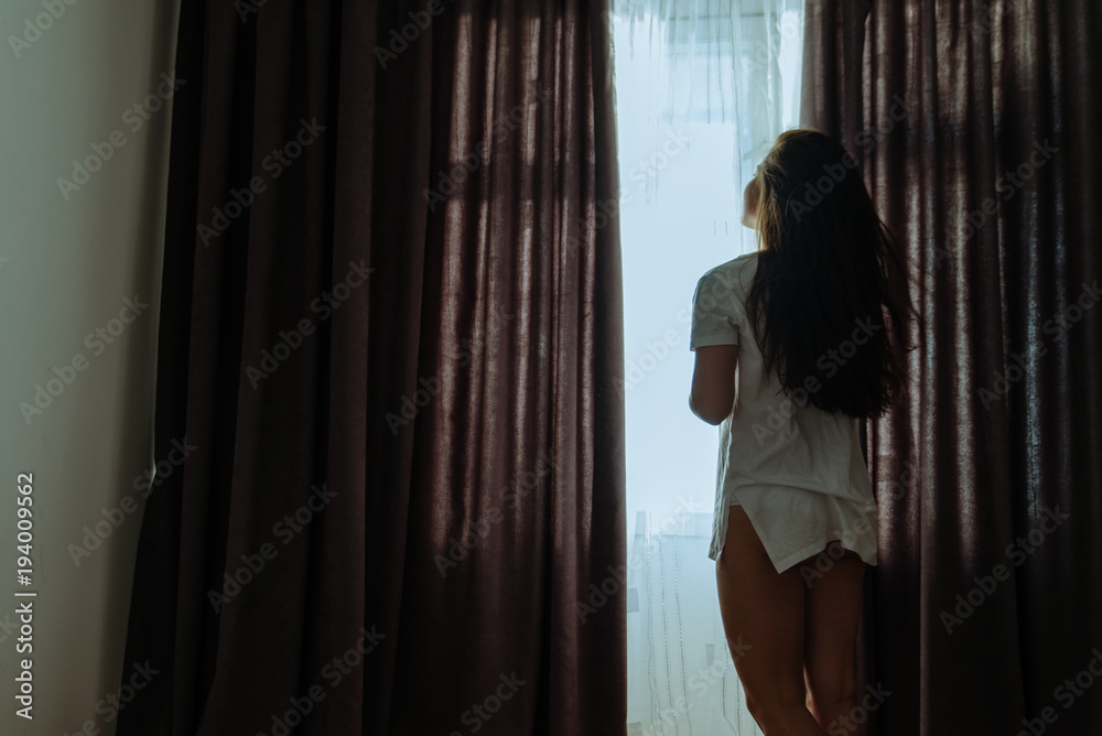 woman drink coffee in the morning near window in white t-shirt