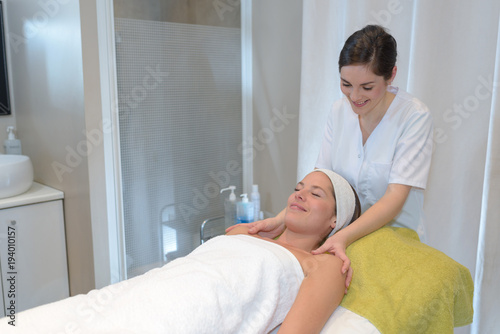 woman client receiving massage by female beautician