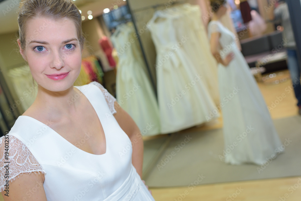 Naklejka premium female trying on wedding dress in a shop