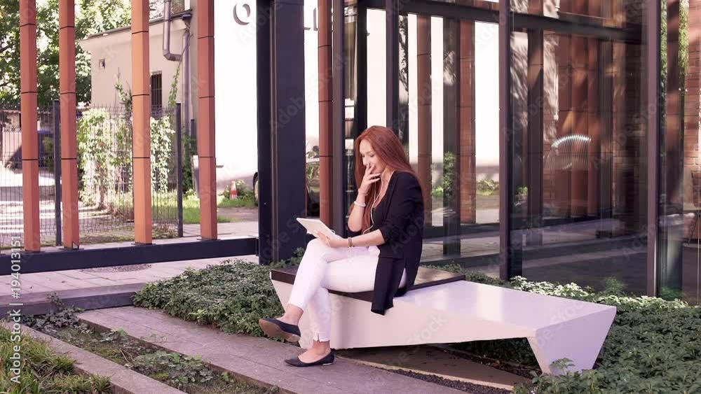 Young, pretty woman with red hair watching movie in the city
Young, pretty woman with red hair watching movie in the city
