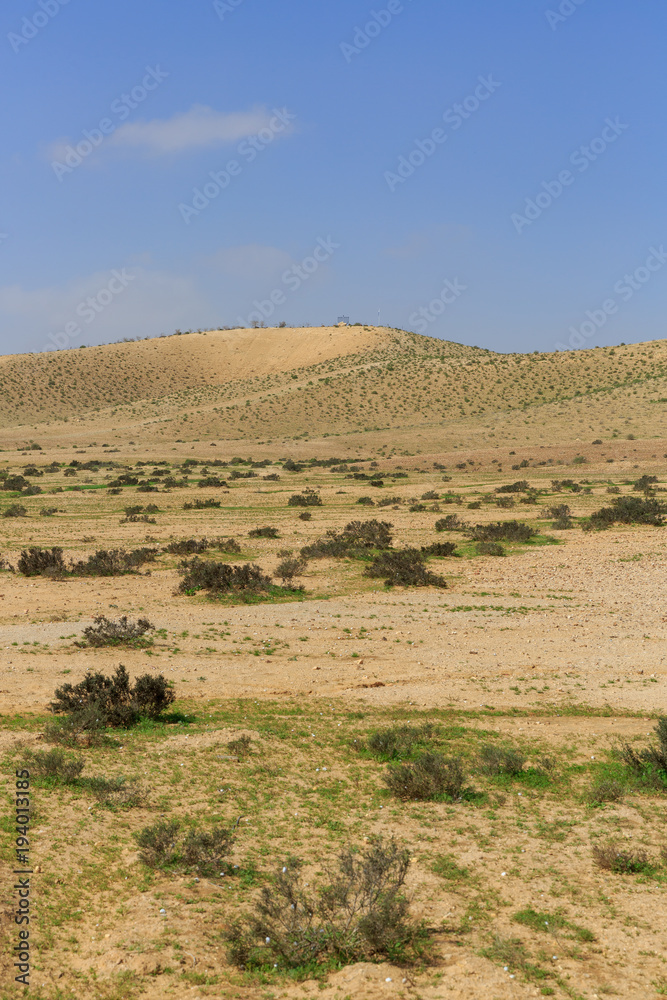 Hill at far in desert under blue sky