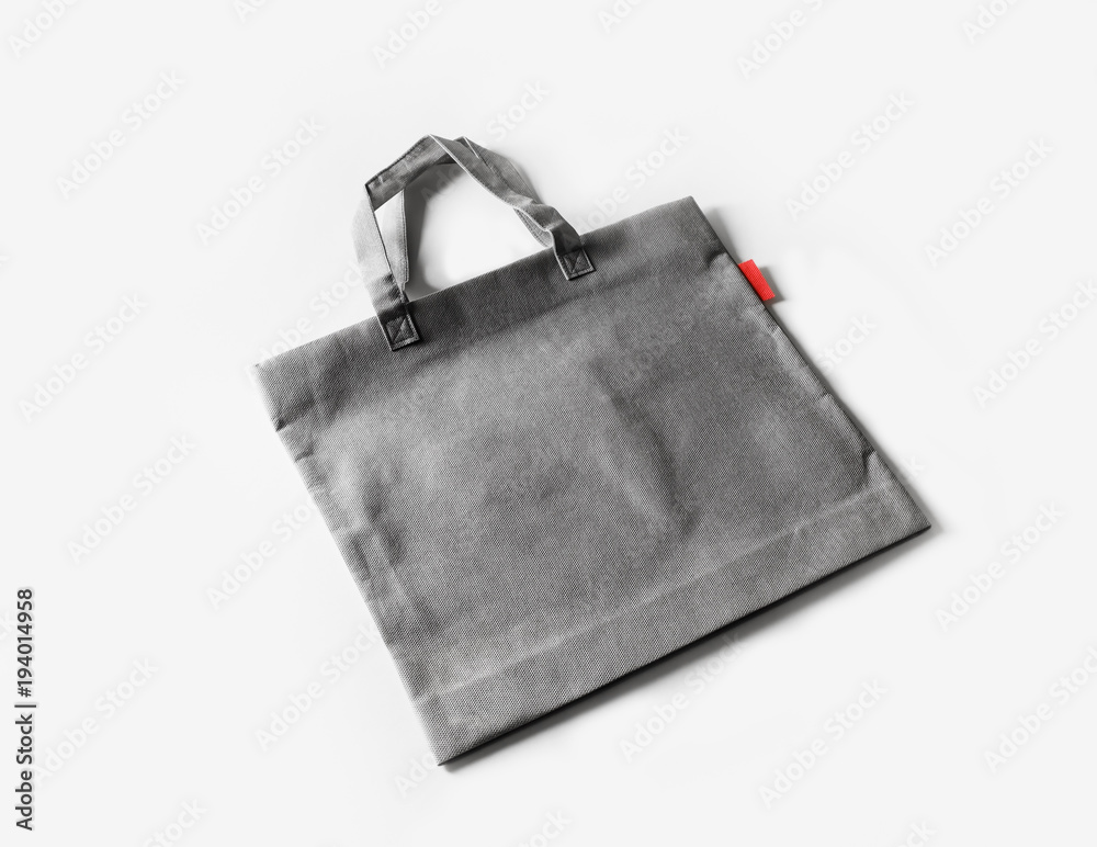 Naklejka premium Blank gray shopping canvas bag on white paper background.