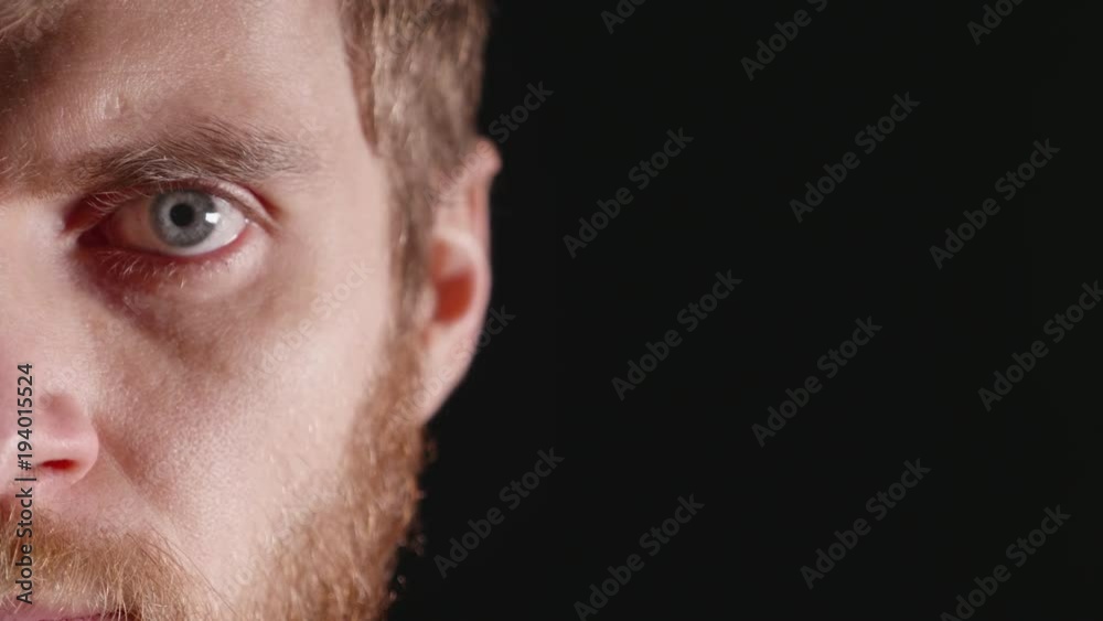 Serious look of a young man in a studio on a black background Serious look of a young man in a studio on a black background