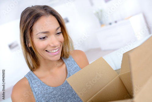 attractive woman opening a cardboard box