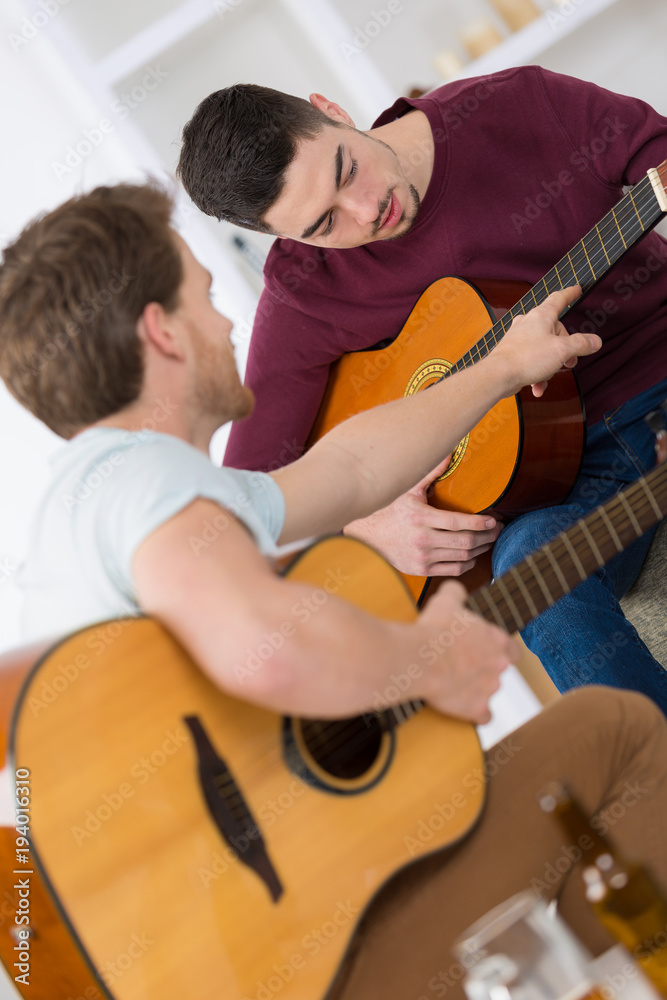 Obraz premium friends resting at home and playing guitar