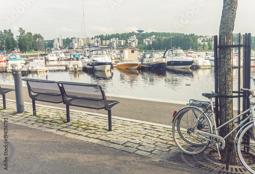 Benches, bicycles and boats on the embankment of Jyvaskyla, Finl © natagolubnycha