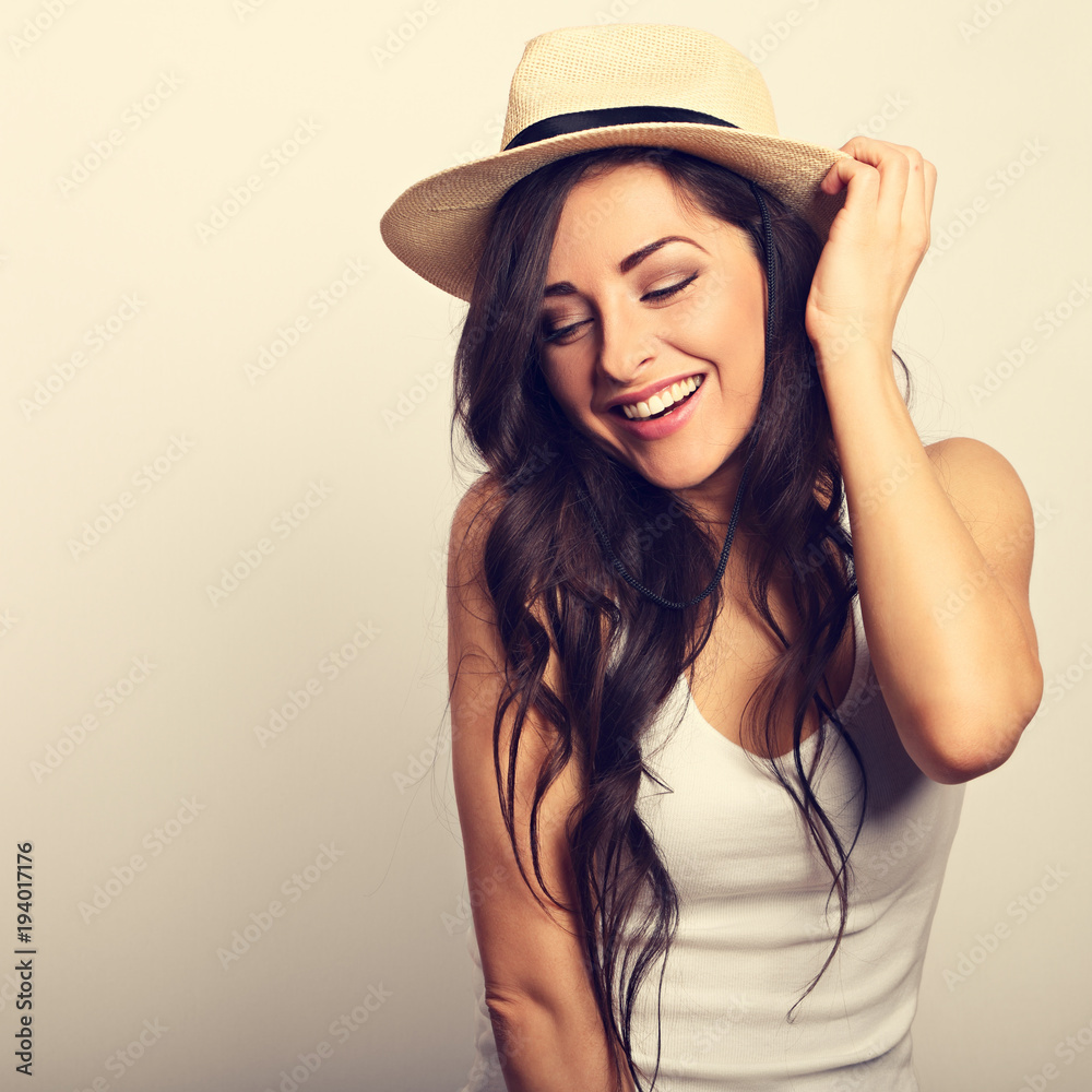 Beautiful long hair laughing woman in white top and straw hat looking happy. Toned vintage portrait Beautiful long hair laughing woman in white top and straw hat looking happy. Toned vintage portrait