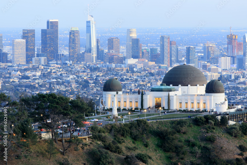 Naklejka premium Griffith Observatory Park z Los Angeles Skyline o zmierzchu. Zmierzchowe widoki na słynny pomnik i centrum miasta ze wschodnich gór Santa Monica. Los Angeles, Kalifornia, USA.