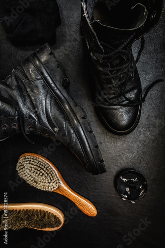 Men's military boots rme shoes, brush and shoe polish against a dark background flat lay top view  photo