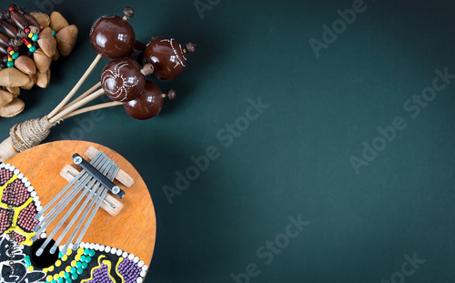 Wooden percussion instruments and kalimba on dark green background photo