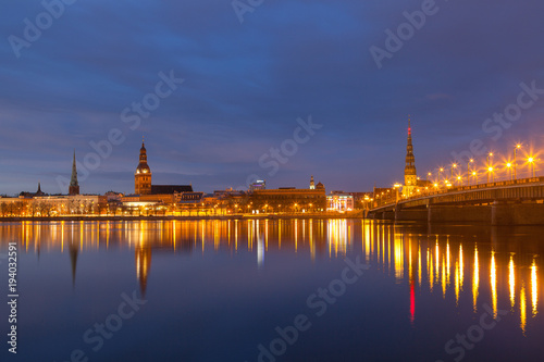 Skyline of old town of Riga seen across the river Daugava with the stone bridge at night.