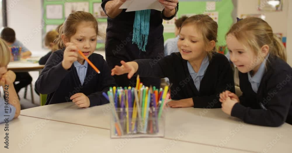 4K Primary school teacher handing out pens & papers to children in the classroom. Slow motion 4K Primary school teacher handing out pens & papers to children in the classroom. Slow motion