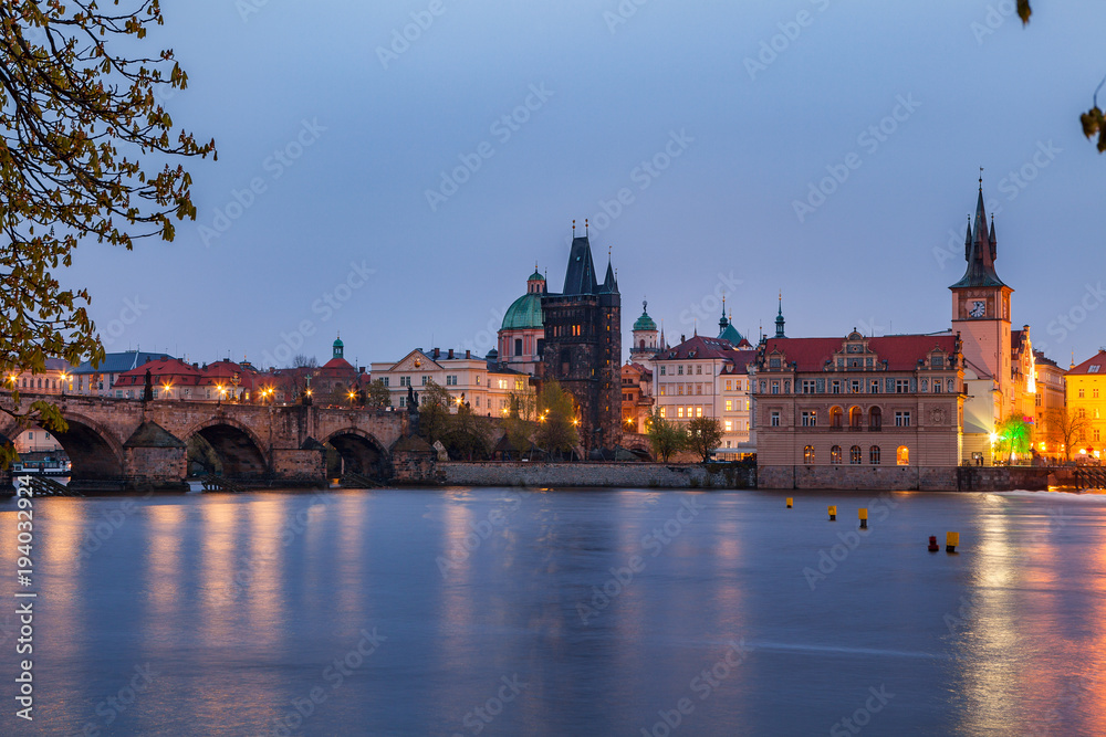 View of night old town of Prague and Charles bridge with reflection in Vltava River