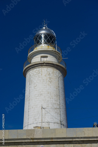 lighthouse next to the Mediterranean Sea, blue sky without clouds with calm waters. serves to warn ships of the presence of rocks