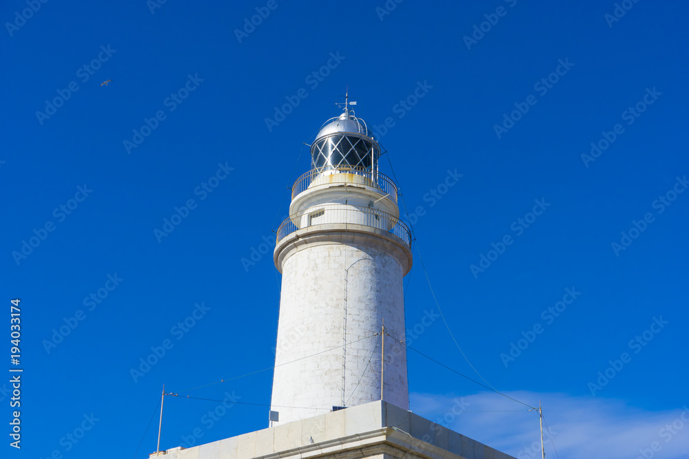 lighthouse next to the Mediterranean Sea, blue sky without clouds with calm waters. serves to warn ships of the presence of rocks