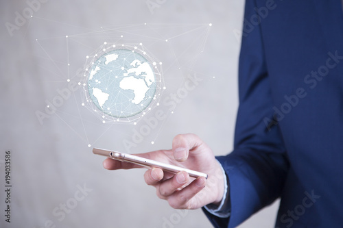 Businessman holding digital tactile world over mobiel phone‘ photo