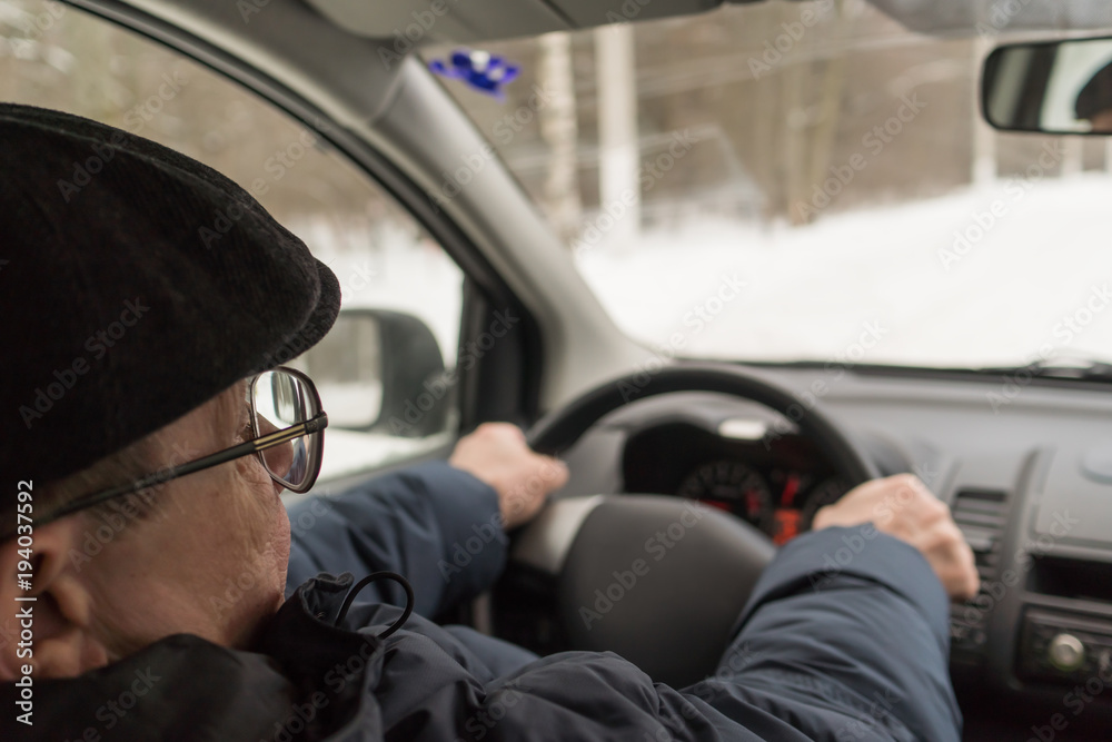 An elderly man is sitting behind the wheel of a car, traveling, active way of life An elderly man is sitting behind the wheel of a car, traveling, active way of life