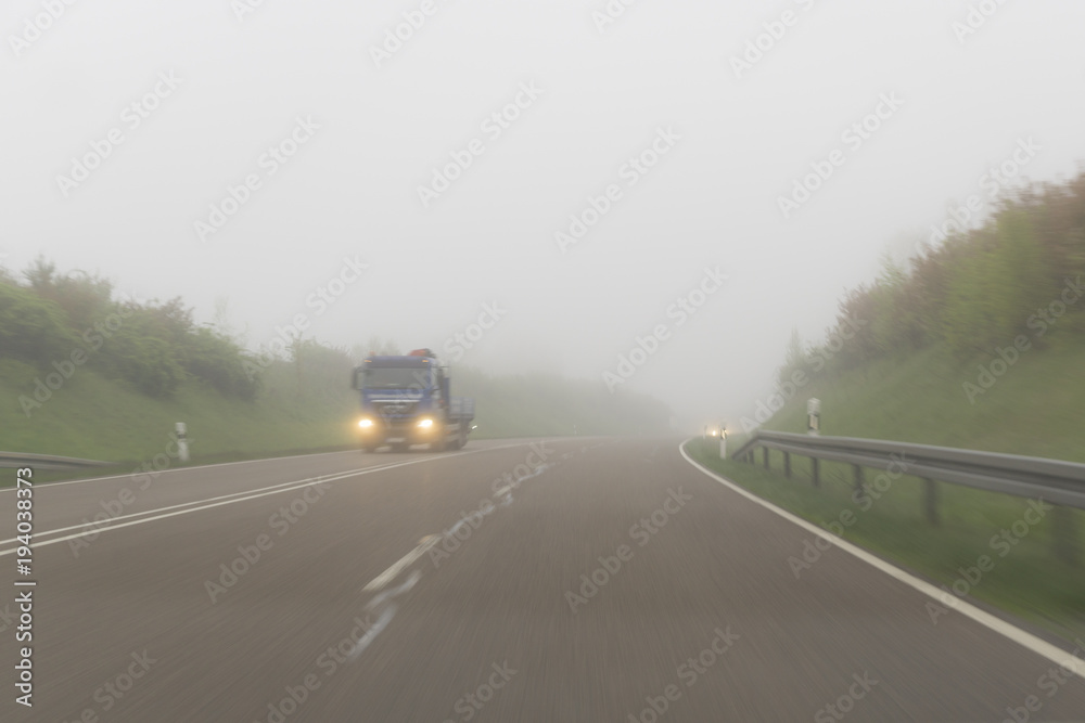 Truck driving on a foggy Road