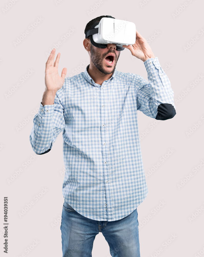 Surprised young man using a virtual reality glasses