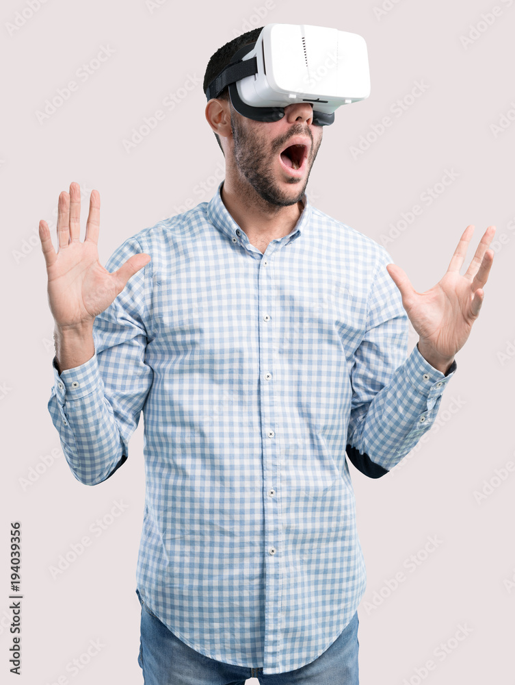 Surprised young man using a virtual reality glasses Surprised young man using a virtual reality glasses