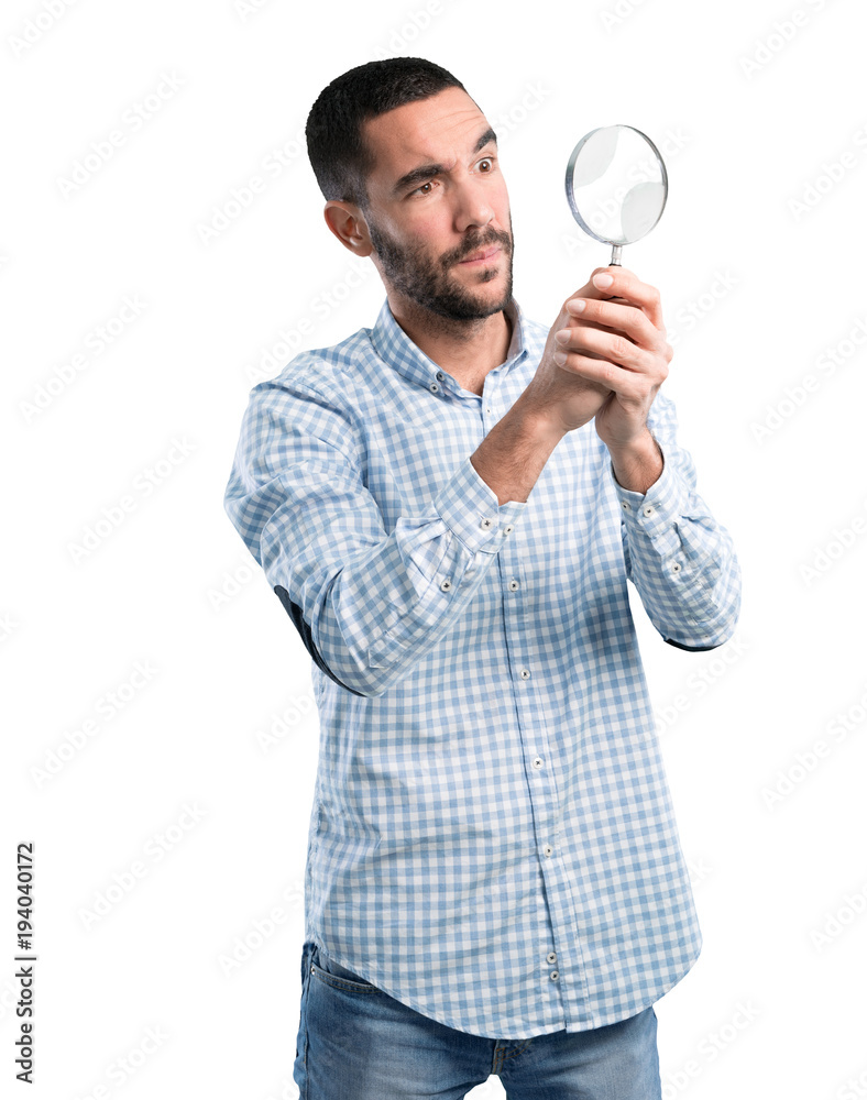Worried young man with a magnifying glass Worried young man with a magnifying glass