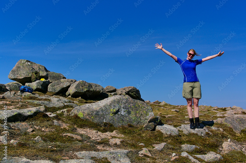 Blond girl with sunglasses wearing athletic clothes on a rocky summit on a sunny day Blond girl with sunglasses wearing athletic clothes on a rocky summit on a sunny day